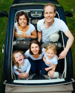 Familie im Auto beim Roadtrip in den Sommerurlaub